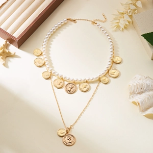 Détail du collier vintage double rang avec perles blanches et pendentifs pièces