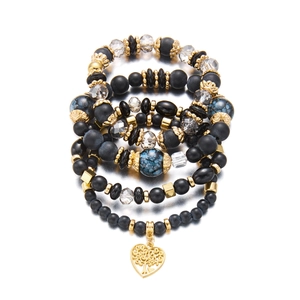 Detail eines böhmischen Mehrlagen-Perlenarmbands mit goldenem Lebensbaum-Herzanhänger
