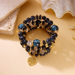 Detail eines böhmischen Perlenarmbands mit blauen Marmorperlen und goldenem Herzanhänger