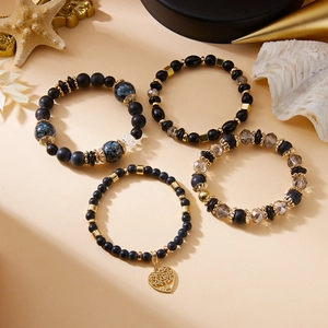 Details von vier Boho-Perlenarmbändern mit Herz-Baum-Anhänger und Kristallsteinen