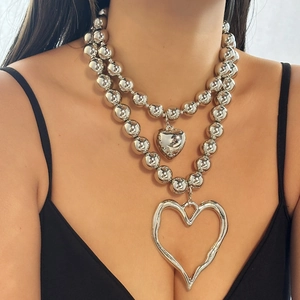 Detail of double-layer silver beaded necklace featuring a large irregular heart pendant
