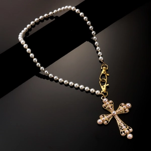 Baroque pearl necklace with large ornate gold cross pendant and pink pearl accents