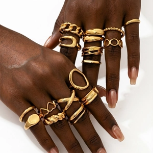 Close-up of golden irregular joint rings with heart designs on a model's hand