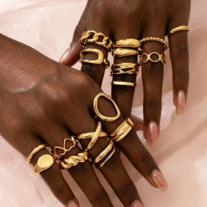 Close-up of a 16-piece set of gold-plated rings in various minimalist and chain designs