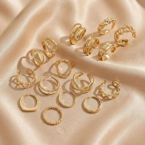 15-piece set of golden minimalist rings featuring chain link and heart designs on silk