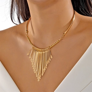 Close-up of golden fringe choker necklace with metallic teardrop tassels on model