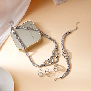 Detailed view of silver mesh jewelry set featuring interlocking crystal-studded rings