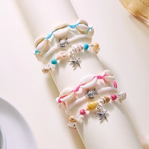 Detail of bohemian starfish shell turtle pendants with braided beads and jewelry charms