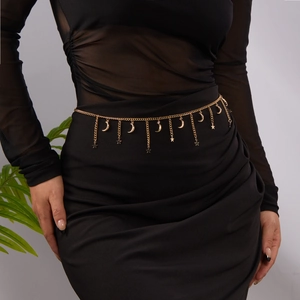 Detailed close-up of golden body chain featuring delicate moon and star shaped pendants