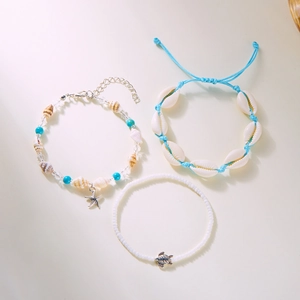 Detail view of woven ocean bracelet set featuring starfish, shells and turtle charms