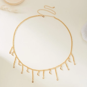 Close-up of golden moon and star charms on adjustable layered snake chain body jewelry