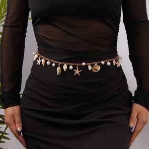 Bohemian gold beach waist chain with starfish shells and pearls on a black dress