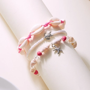 Detail of bohemian shell and starfish charms on pink braided cord 3-piece bracelet set