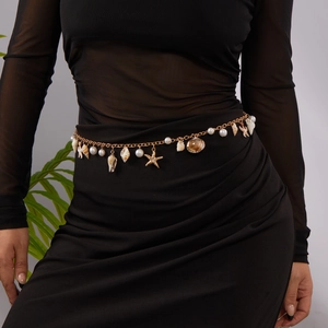 Detail of bohemian gold waist chain with seashell, starfish charms and white pearls