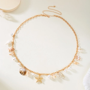 Detailed close-up of gold body chain with starfish, seashells and pearl charms