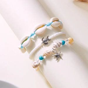 Detail of bohemian beach jewelry set with shell starfish turtle charms and blue beads