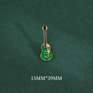 Dettaglio macro di una spilla a chitarra elettrica verde con finiture oro, 15mm x 39mm