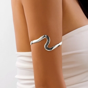Vue détaillée d'un bracelet de bras ondulé argenté minimaliste sur le haut du bras