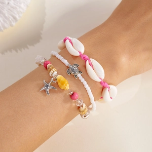 Close-up of bohemian starfish and shell charms on 3-piece woven beach bracelet set