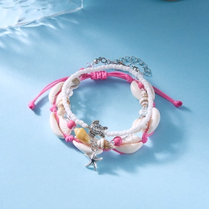 Detailed view of ocean style bracelet set with conch shells and metal turtle pendant