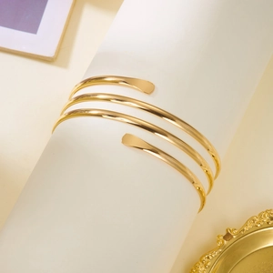 Détail d'un bracelet de bras spirale doré multicouche avec une finition polie miroir