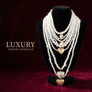 Détail d'un collier de perles à cinq rangs avec cœurs dorés et breloque en émail rose