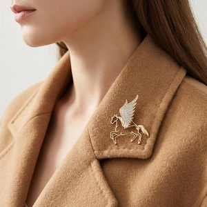 Luxury gold Pegasus brooch with crystal wings on brown cashmere coat collar
