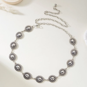 Detail view of Bohemian silver metal waist chain with circular carved patterns and lobster clasp