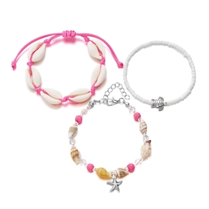 Detail of beach jewelry set featuring conch shells, starfish charms, and sea turtle pendant