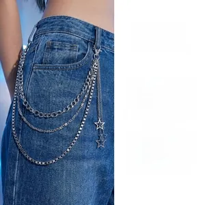 Detail of silver triple-layered metal waist chain featuring star pendants on blue denim