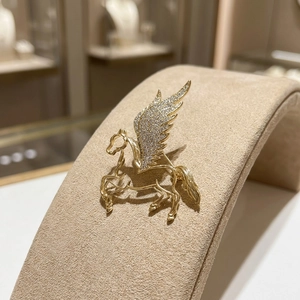 Detailed macro view of the gold Pegasus brooch with sparkling wings and fine craftsmanship