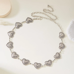 Detailed close-up of retro silver heart-shaped metal waist chain with floral engravings