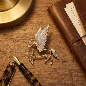 Macro shot of luxury pegasus brooch with crystal wings on vintage notebook
