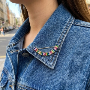 Broche arc-en-ciel en zircon avec gemmes colorées sur un col de veste en jean