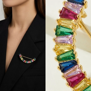 Détail macro d'une broche en zircon arc-en-ciel plaquée or sur revers de costume