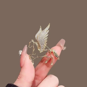 Detailed view of luxury gold Pegasus brooch with shimmering inlaid crystals and wings
