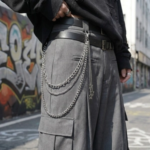 Detail view of multi-layer silver metal pants chain with star pendants on cargo pants