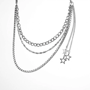 Macro detail of multi-layered silver metal waist chain with hollow pentagram star pendants