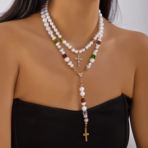 Détail d'un collier de perles à double rangée avec croix dorées et perles colorées sur modèle