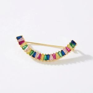Détail d'une broche arc-en-ciel incurvée avec cristaux multicolores montés sur doré