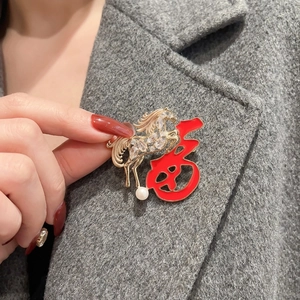 Détail de la broche cheval du zodiaque avec caractère Fu rouge et perle sur un manteau