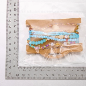 Detail of colorful bohemian beaded bracelets with shell charm on display card