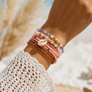 Close-up of Bohemian layered bead bracelets with shells and pearls for summer beach wear