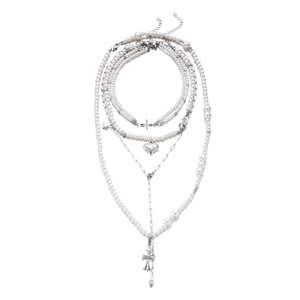 Détail d'un ensemble de colliers superposés avec perles baroques, cœurs et croix argentées