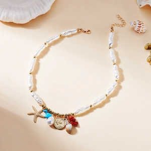 Détail du collier de perles baroques avec pendentifs étoile de mer, pierre et pièce