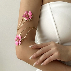 Bracelet de bras doré élégant avec fleurs en émail rose sur un anneau enroulable