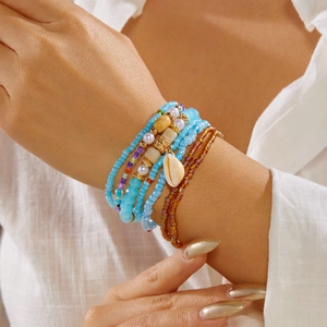 Detailed view of bohemian multilayer bead bracelet featuring a natural shell pendant