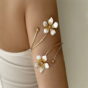 Détail du bracelet de bras spirale avec fleurs en émail blanc et finition dorée