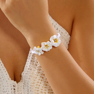 Detailansicht der weißen Plumeria-Blütenarmband mit Kristallen und Handwebung