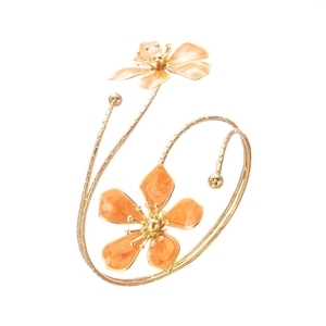 Détail d'un bracelet spirale doré orné de deux fleurs en émail orange vif éclatant